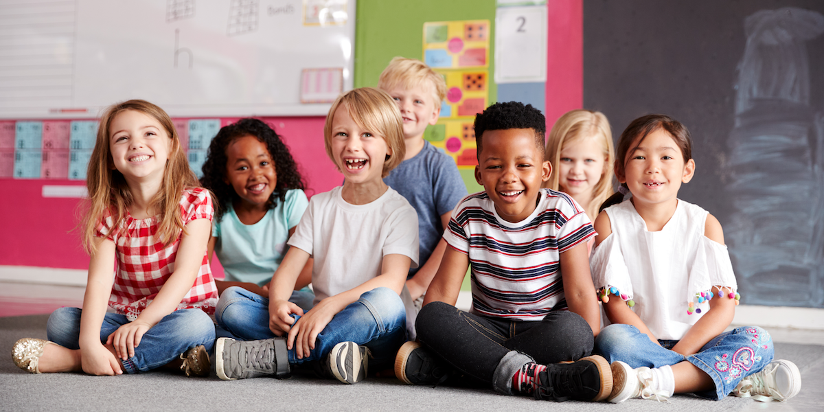 Happy elementary students, colorful classroom